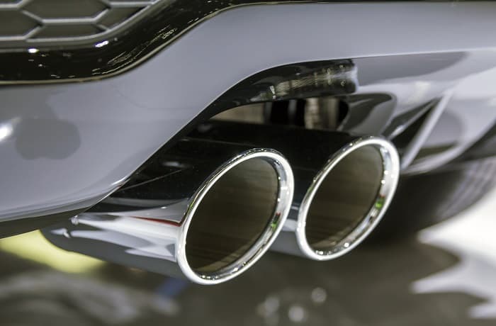 Double chrome exhaust pipe of powerful sport car with grey plastic details