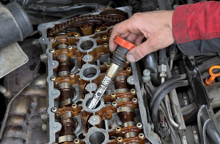 Car mechanic replacing ignition coil on gasoline engine