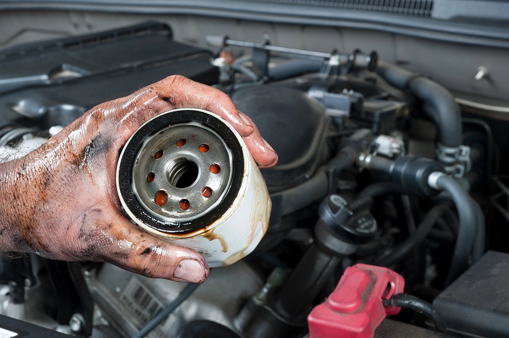 Auto mechanic holding oil filter